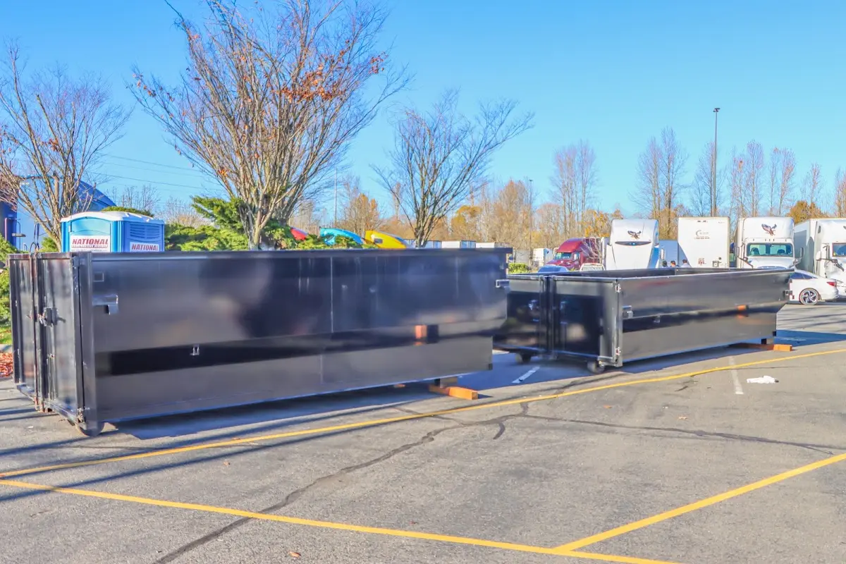 Professional dumpster rental service with roll-off container on residential driveway in Geddes